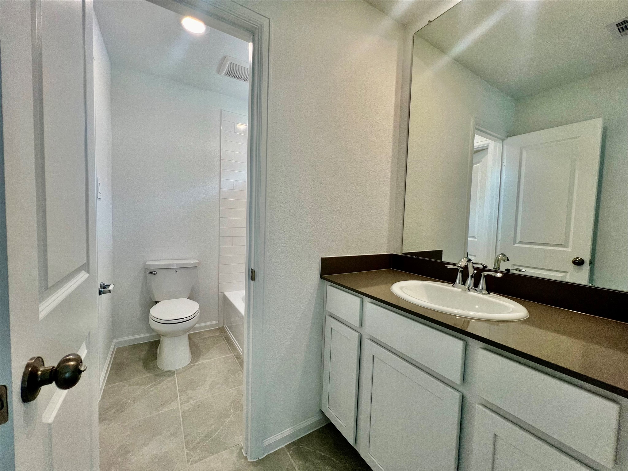 17771 Misty Brk Lane Conroe, TX 77302 - Photo 32 of 48 a bathroom with a granite countertop toilet a sink and a mirror
