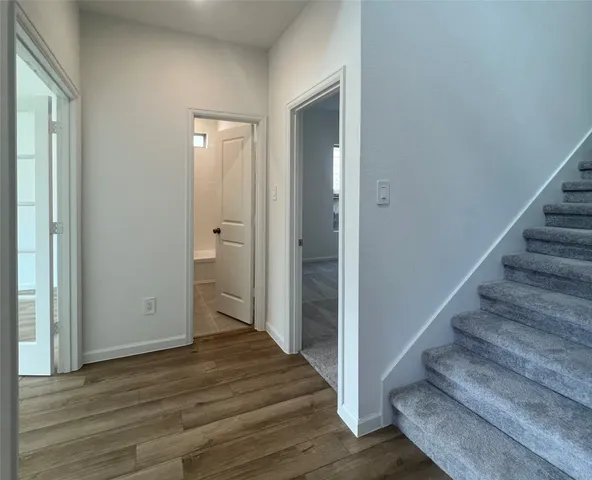 a view of a hallway with wooden floor and entryway