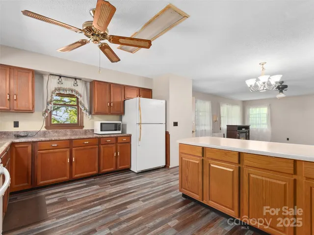 a kitchen with cabinets a center island stainless steel appliances and a window