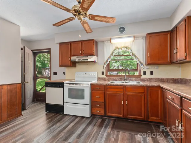 a kitchen with a stove a sink and a window