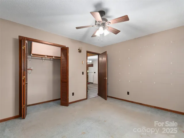 an empty room with closet and fan