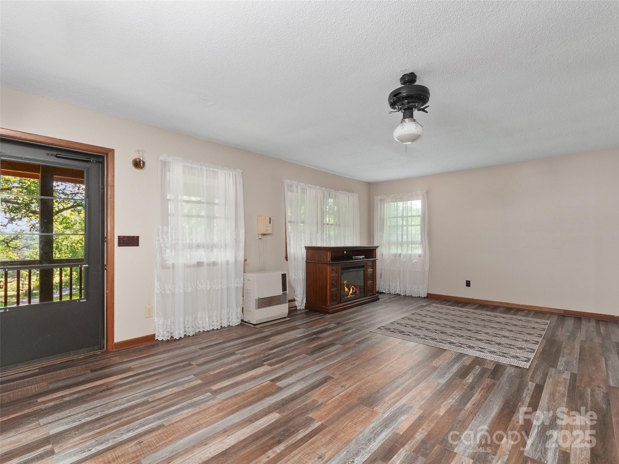 250 Turkey Pen Road Franklin, NC 28734 - Photo 6 of 30 a view of an empty room with a fireplace and a window