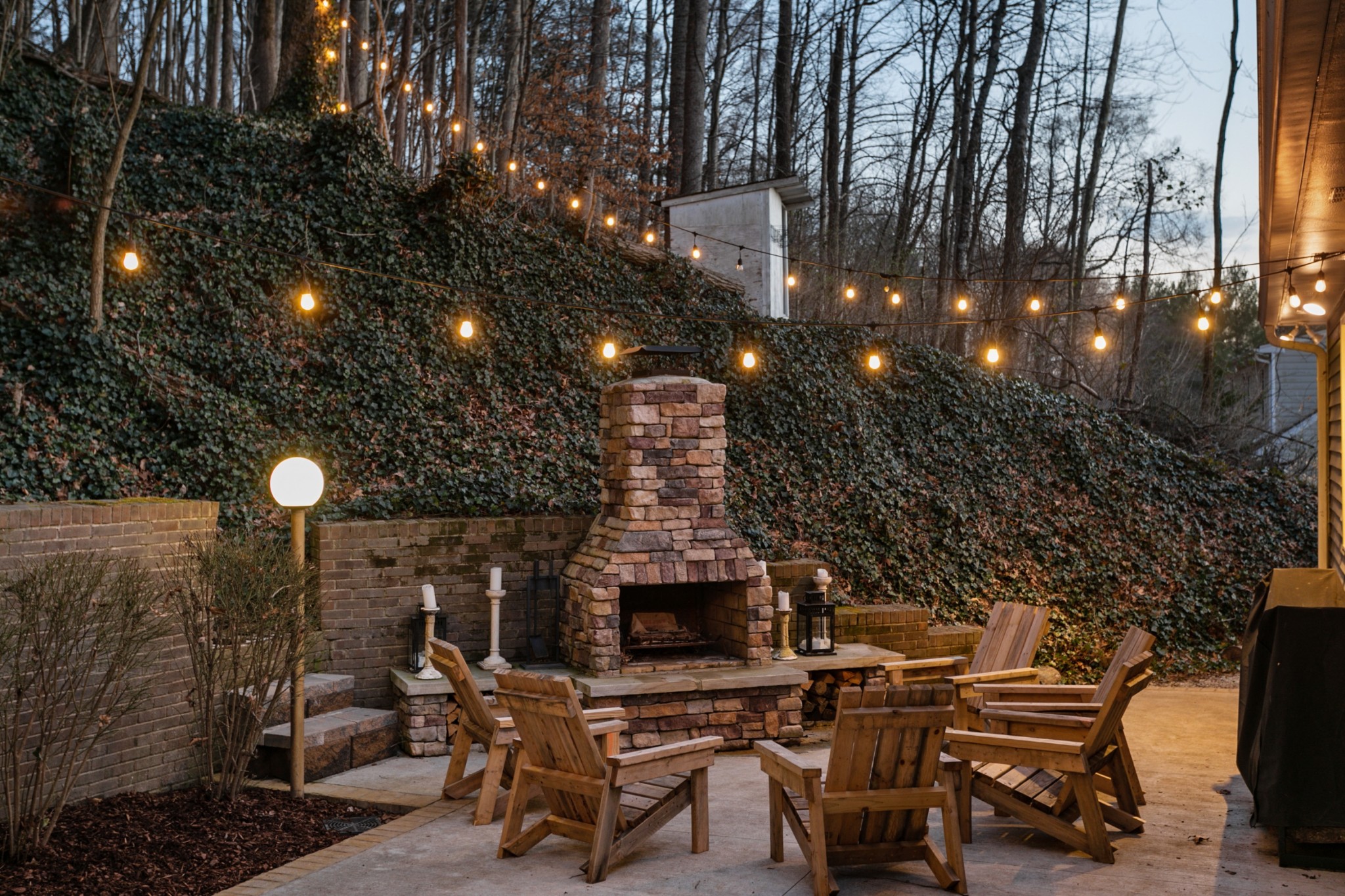 754 High Point Ridge Road Franklin, TN 37069 - Photo 45 of 53 a view of a patio with dining table and chairs with a fire pit and a barbeque grill with floor and large trees
