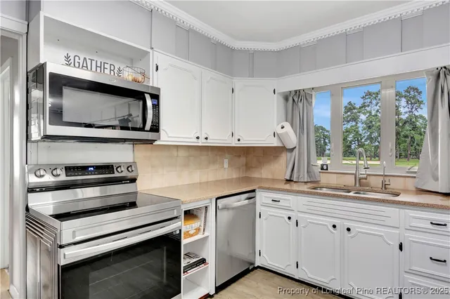 a kitchen with granite countertop cabinets stainless steel appliances and window