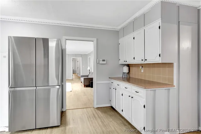 a kitchen with white cabinets and sink
