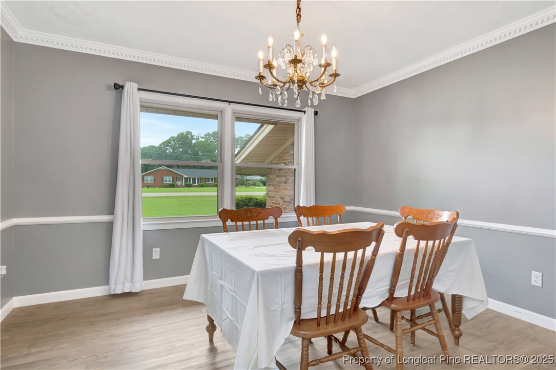 12073 Highway 130 Fairmont, NC 28340 - Photo 17 of 45 a view of a dining room with furniture a chandelier and wooden floor