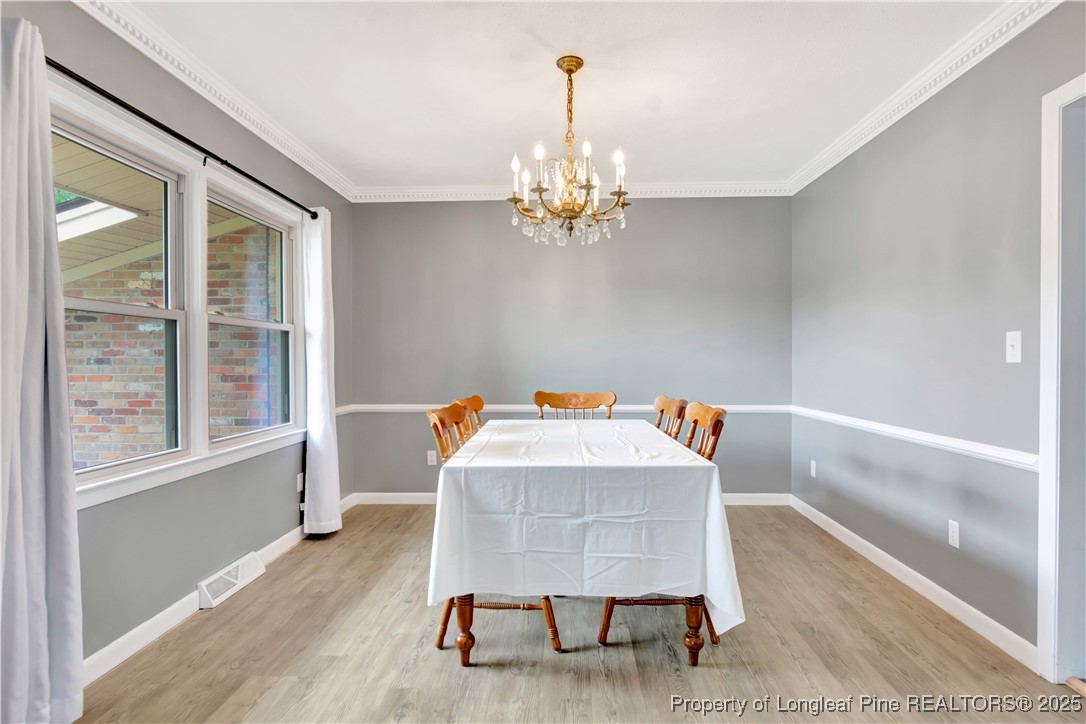 12073 Highway 130 Fairmont, NC 28340 - Photo 18 of 45 a view of a dining room with furniture a chandelier and wooden floor