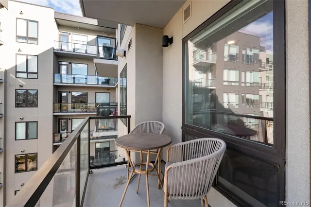 a front view of building with an entrance and plants