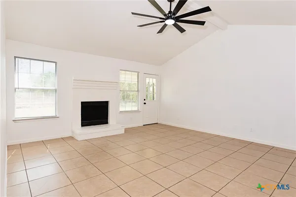 a view of empty room with cabinet and fireplace