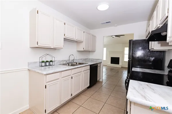 a kitchen with stainless steel appliances a sink a stove a refrigerator and cabinets