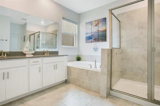 a bath room with a sink mirror and a bathtub