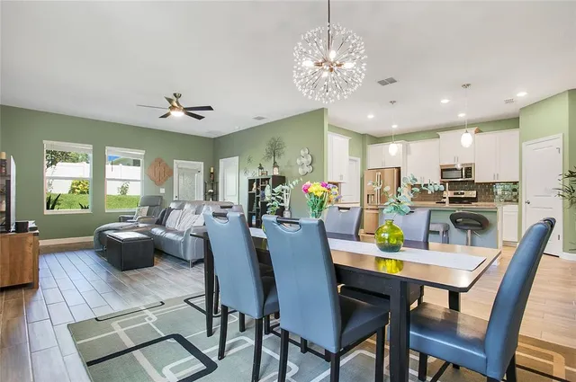 a view of a dining room with furniture a livingroom and chandelier