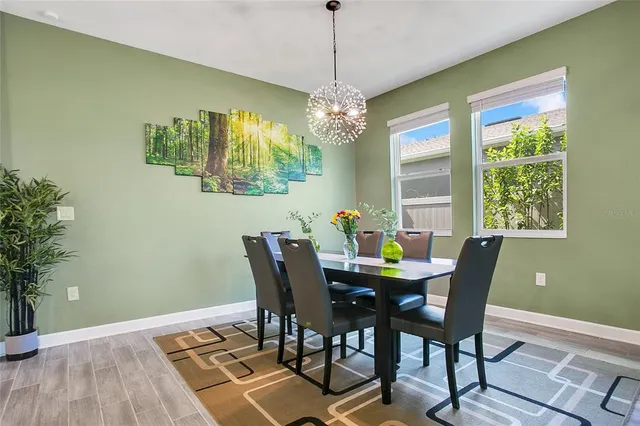a view of a dining room with furniture a chandelier and wooden floor
