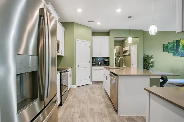 a kitchen with stainless steel appliances a sink stove and refrigerator