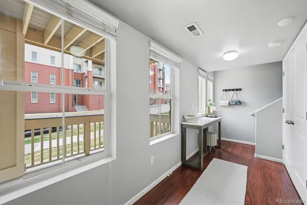 a hallway with a large mirror and dining table with wooden floor