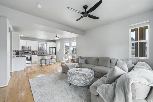 a living room with furniture and a view of kitchen