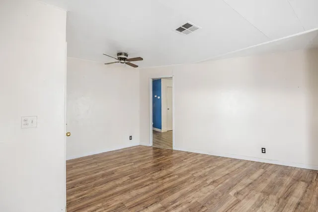 a view of empty room with wooden floor