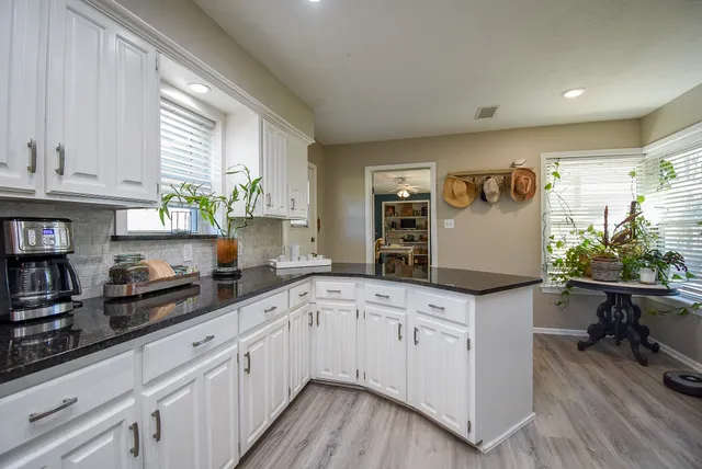 a kitchen with granite countertop white cabinets and white appliances