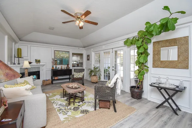 a living room with furniture dining table a chandelier and a potted plant