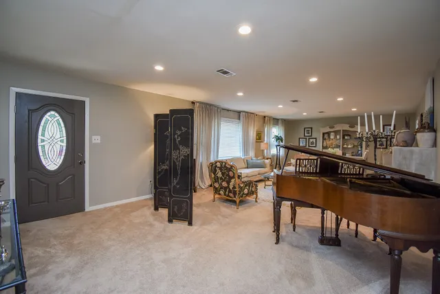 a living room with furniture a clock and a table