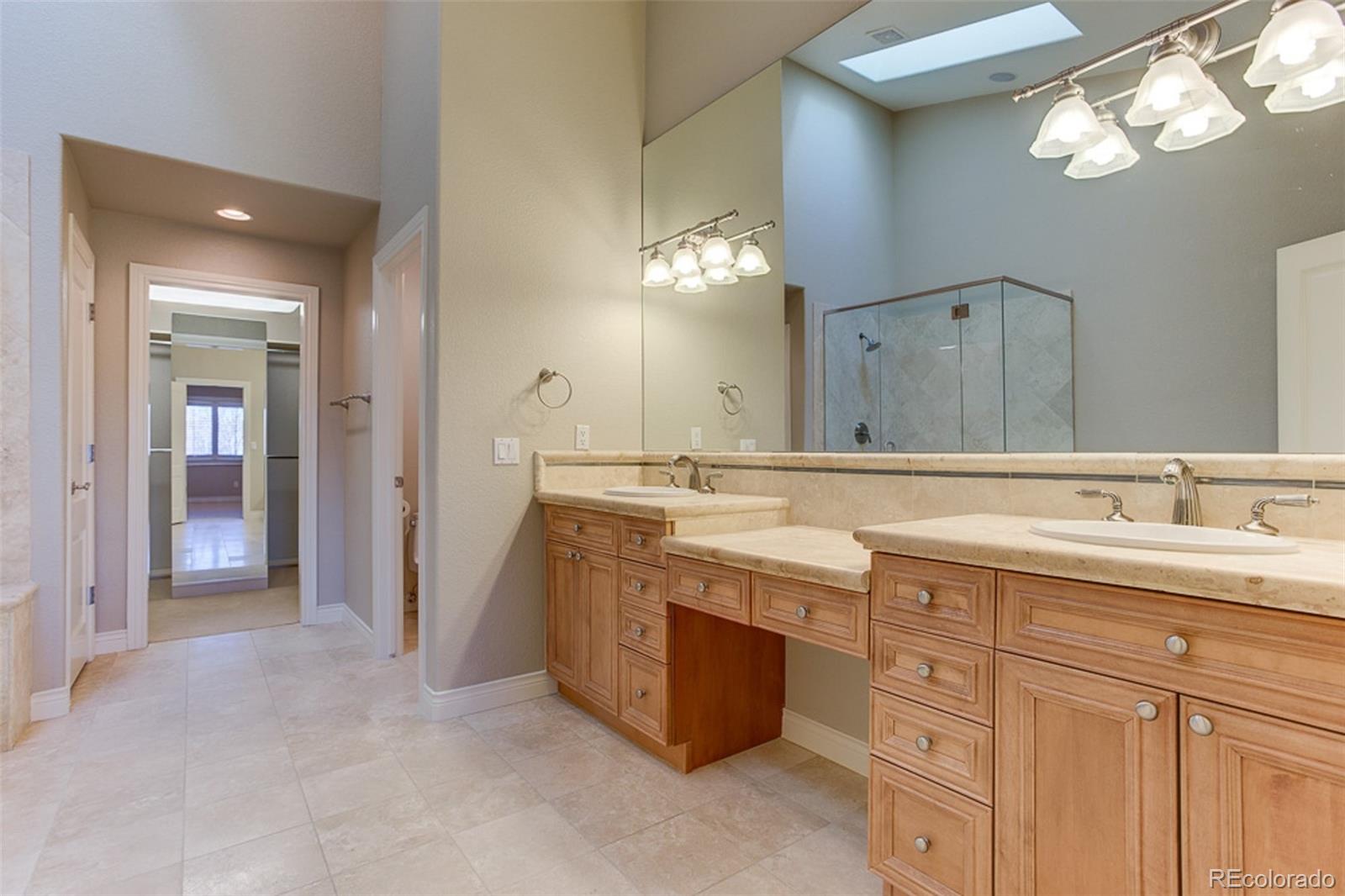 338 St Paul Street Denver, CO 80206 - Photo 19 of 35 a bathroom with a granite countertop sink a large mirror and a shower