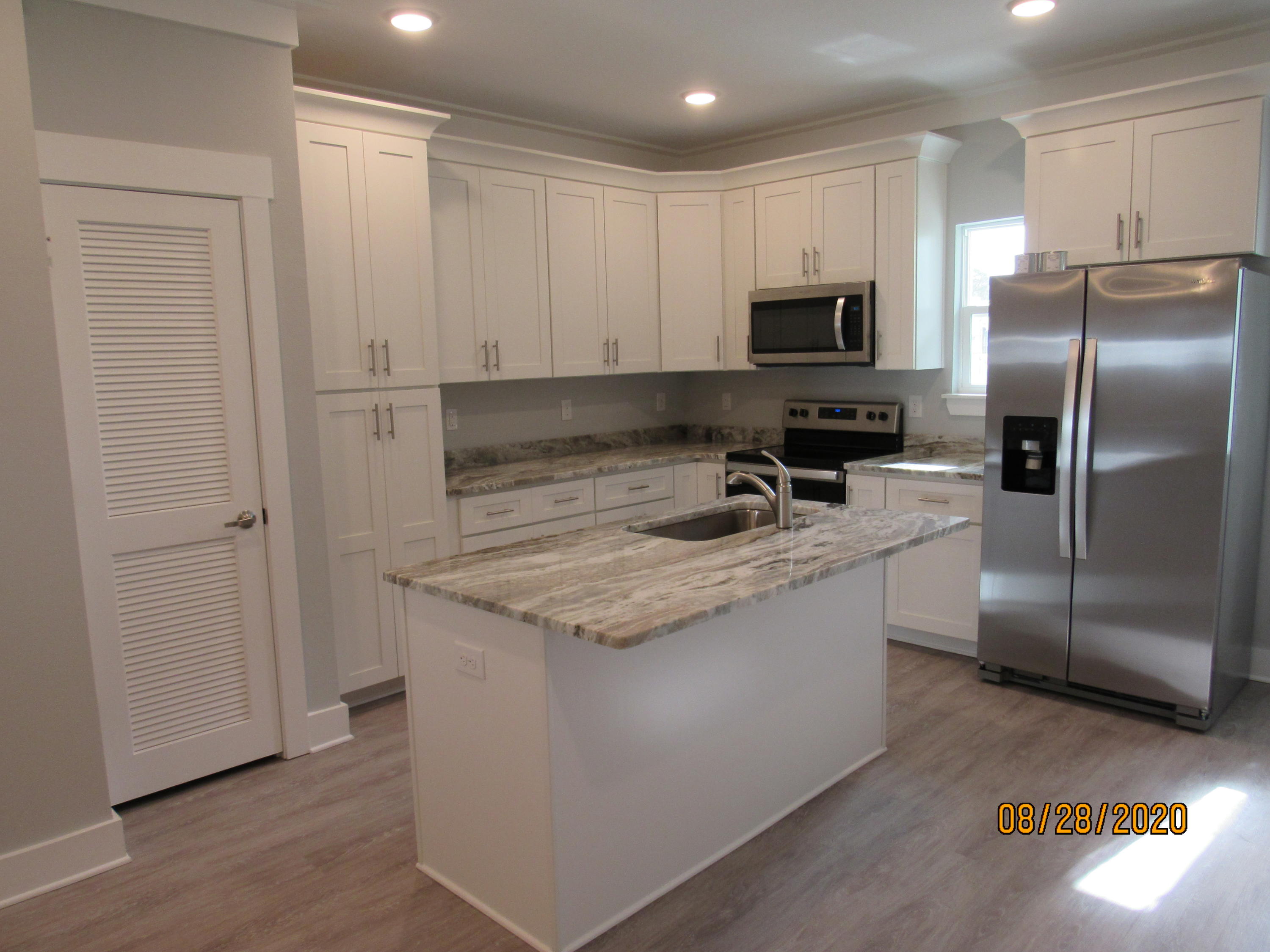 69 South Sand Palm Road Freeport, FL 32439 - Photo 3 of 13 a kitchen with stainless steel appliances granite countertop a sink a stove and a refrigerator