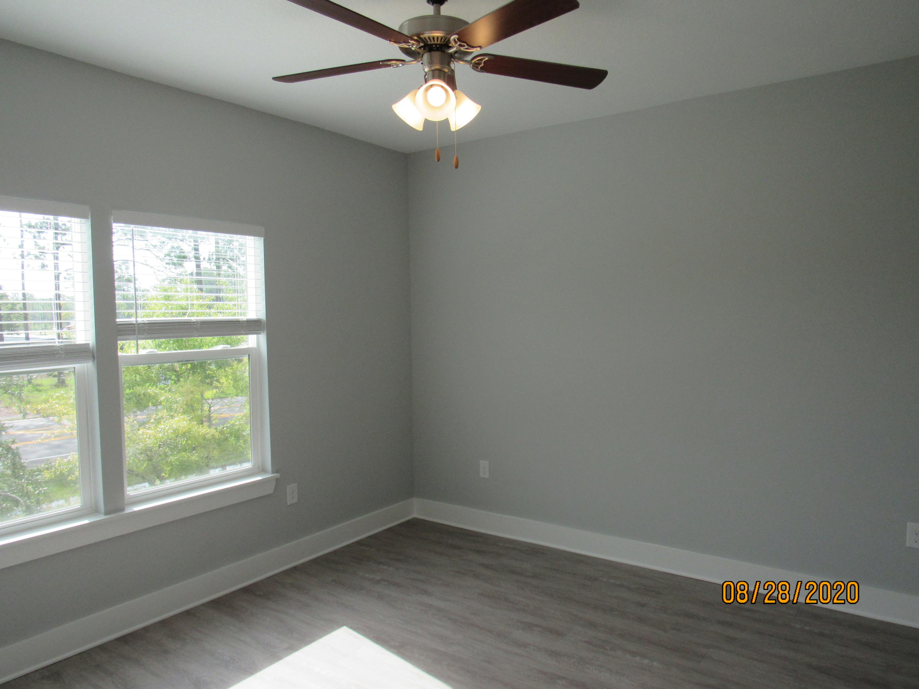 69 South Sand Palm Road Freeport, FL 32439 - Photo 6 of 13 an empty room with wooden floor fan and windows