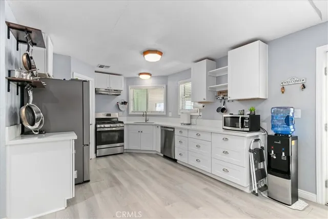 a kitchen with stainless steel appliances a refrigerator sink and cabinets