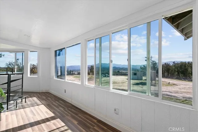 a view of a room with wooden floor and windows