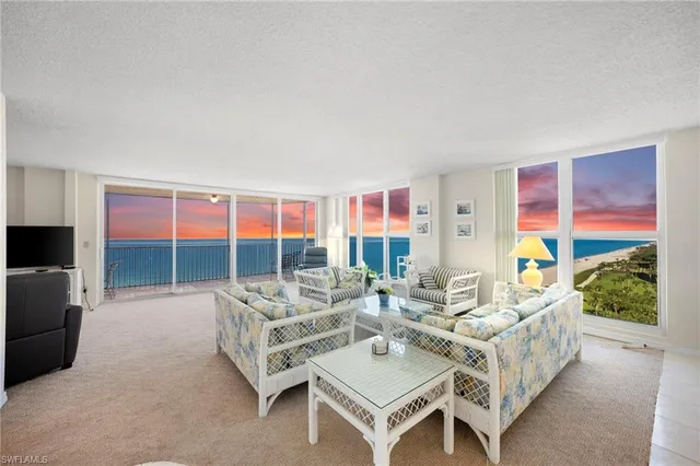 a living room with furniture and a floor to ceiling window