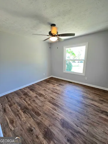 a view of empty room with wooden floor