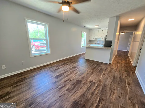 an empty room with wooden floor and windows