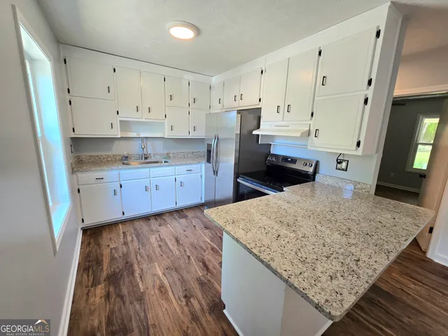 a kitchen with granite countertop wooden cabinets and a sink