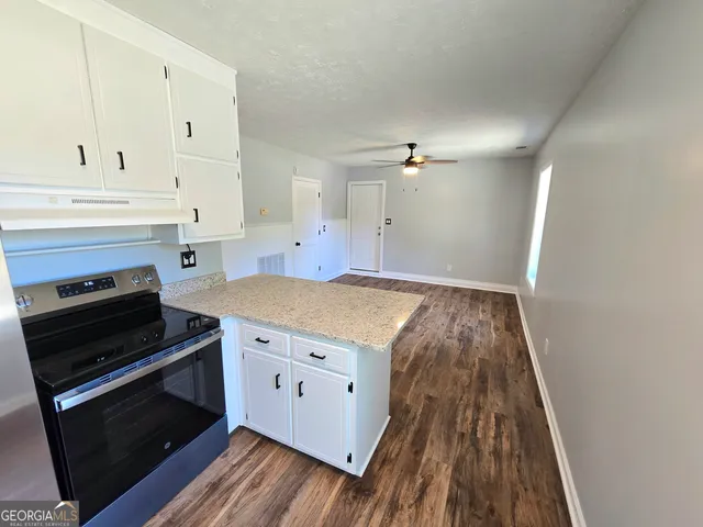 a kitchen with a stove and white cabinets