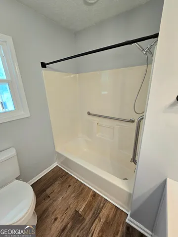 a bathroom with a toilet and a shower
