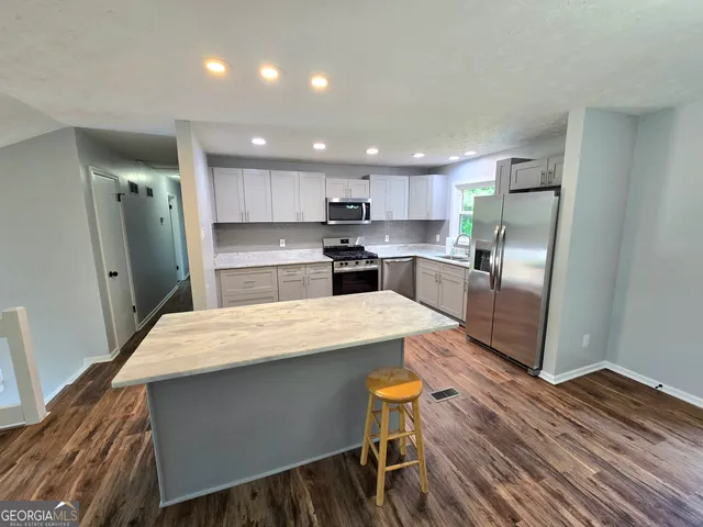 a large kitchen with a table and chairs