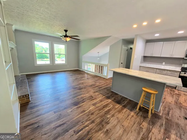 an open kitchen with wooden floors and white walls