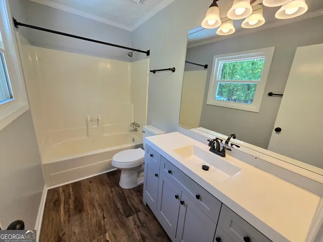a bathroom with a double vanity sink toilet mirror and shower