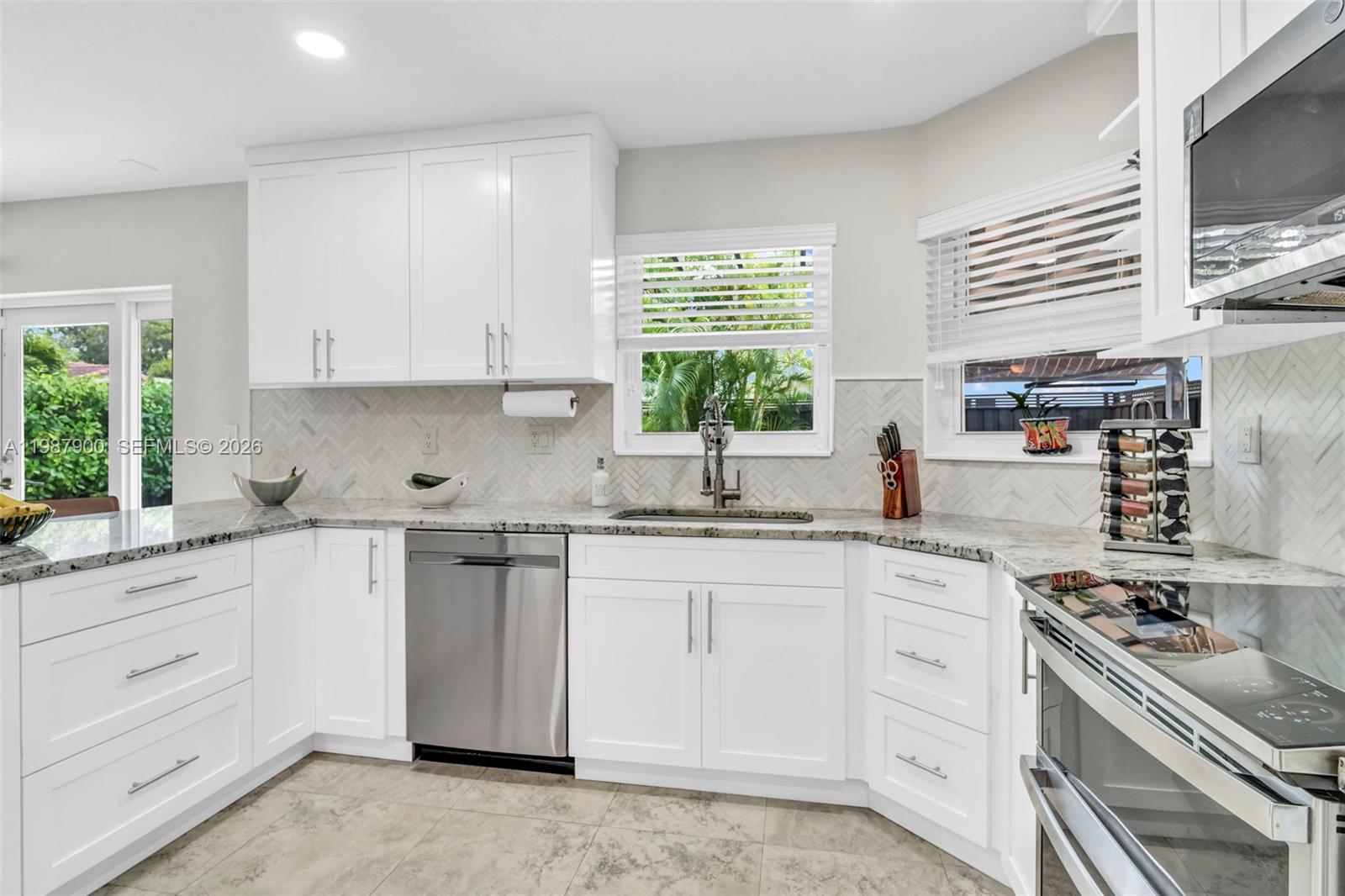 15726 Southwest 76th Terrace Miami, FL 33193 - Photo 11 of 34 a kitchen with granite countertop white cabinets and white appliances