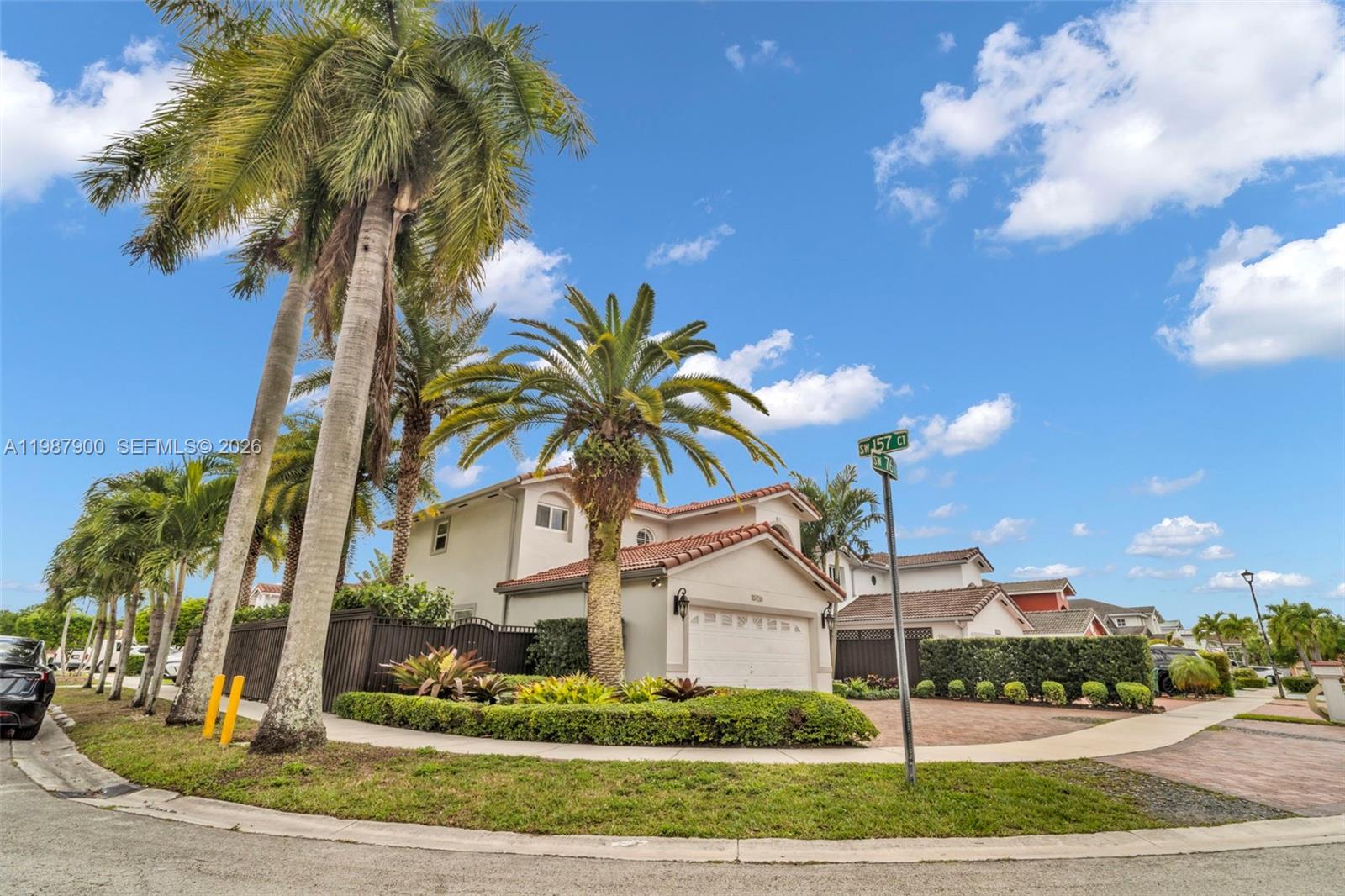 15726 Southwest 76th Terrace Miami, FL 33193 - Photo 2 of 34 a view of a white house with a yard and plants