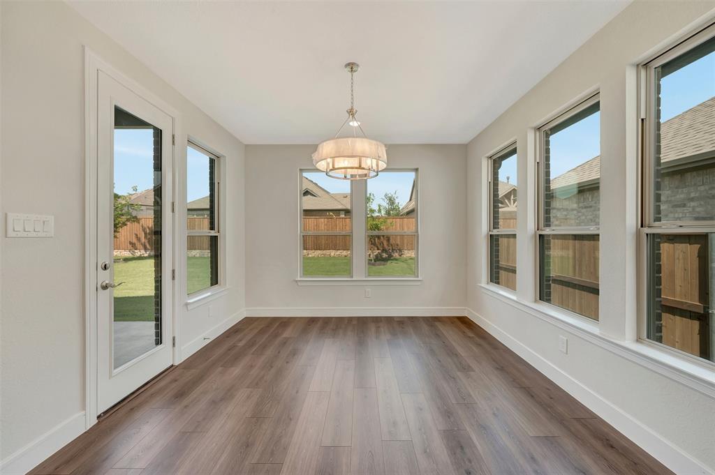 11460 Wulstone Road Fort Worth, TX 76052 - Photo 12 of 40 a view of an empty room with wooden floor and a window