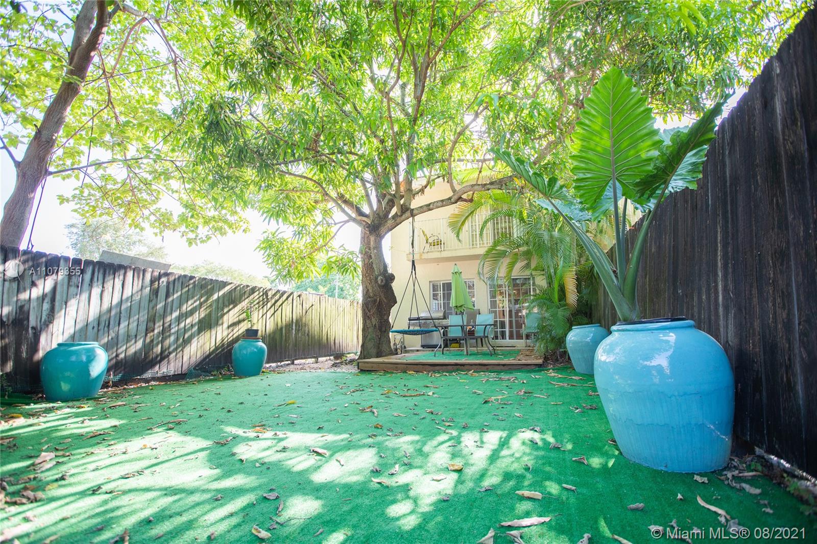 3053 Elizabeth Street, Unit 3053 Miami, FL 33133 - Photo 1 of 42 a view of a backyard with table and chairs and wooden fence