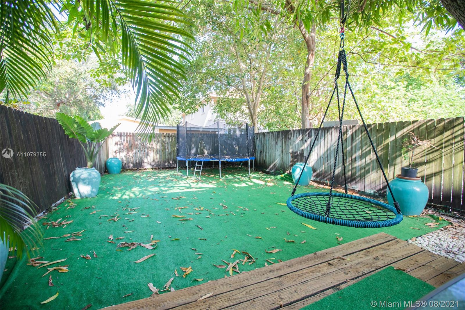 3053 Elizabeth Street, Unit 3053 Miami, FL 33133 - Photo 33 of 42 a view of a backyard with plants and a slide