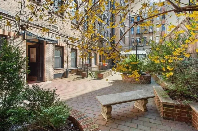 a wooden bench sitting in front of a building
