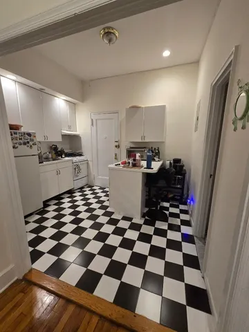 a kitchen with a checkered floor and white cabinets