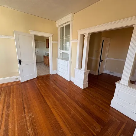 a view of empty room with wooden floor and stairs
