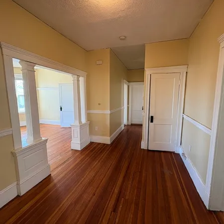 a view of a hallway with wooden floor and staircase