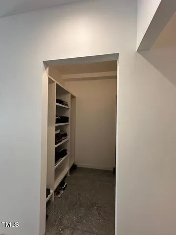 a view of walk in closet with empty racks