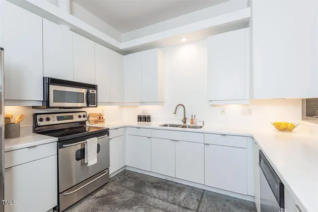 a kitchen with a sink and white cabinets