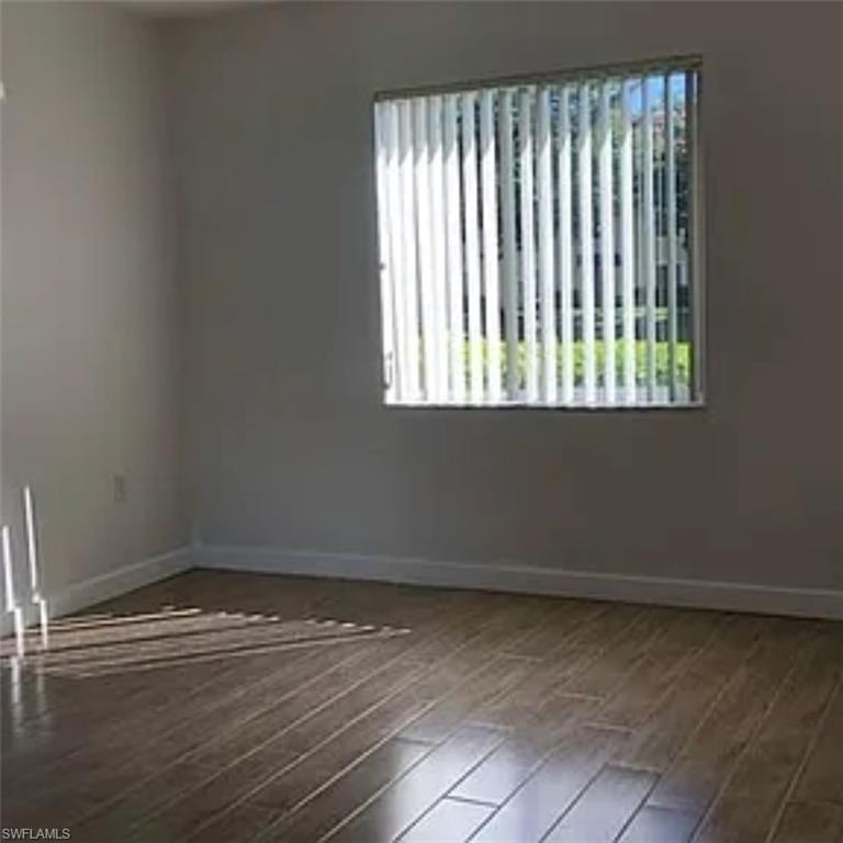 8304 Key Royal Circle, Unit 1712 Naples, FL 34119 - Photo 6 of 14 Unfurnished room featuring healthy amount of natural light and wood finished floors